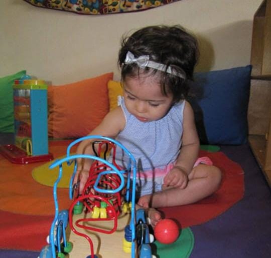 Niña pequeña explorando un juego de encaje