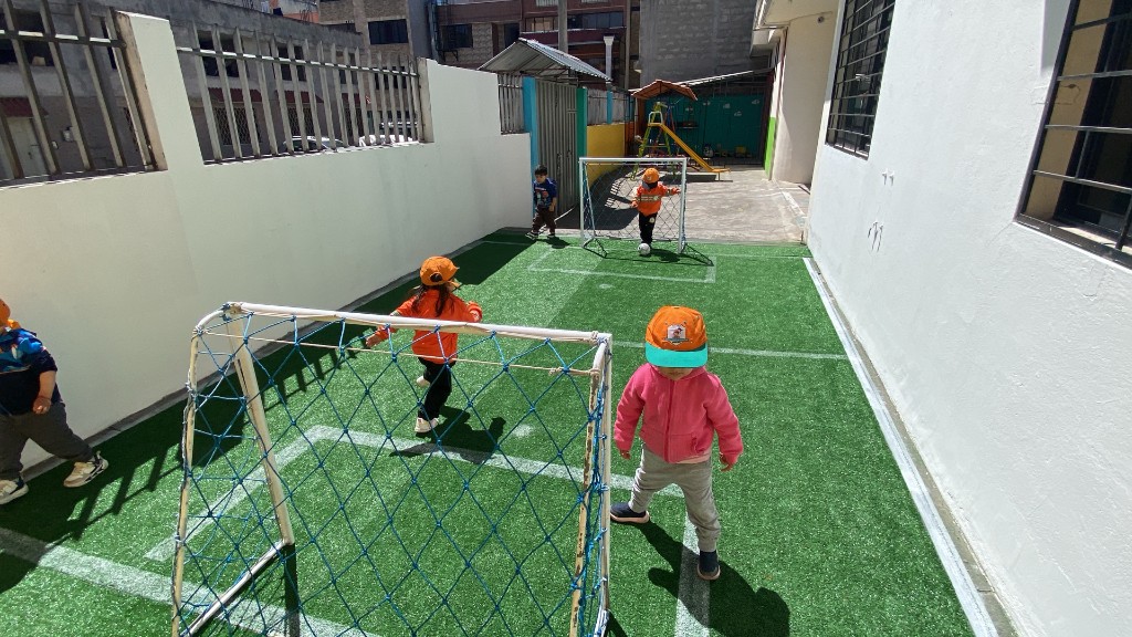 Niños jugando fútbol en el patio
